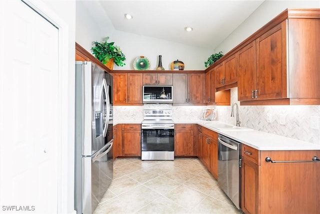 kitchen featuring sink, stainless steel appliances, tasteful backsplash, vaulted ceiling, and light tile patterned flooring