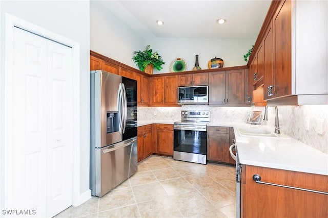 kitchen with light tile patterned floors, backsplash, stainless steel appliances, and sink