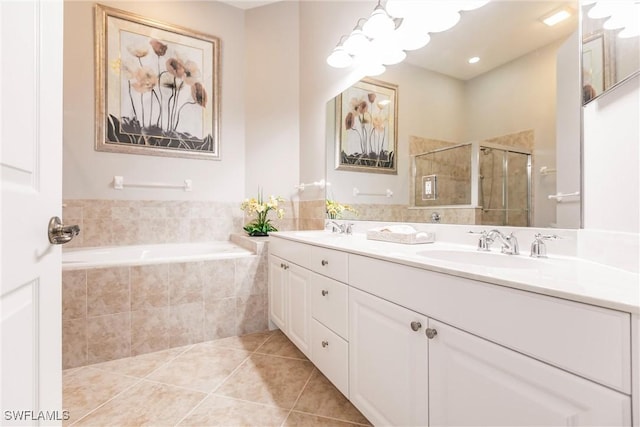 bathroom with tile patterned floors, vanity, and shower with separate bathtub