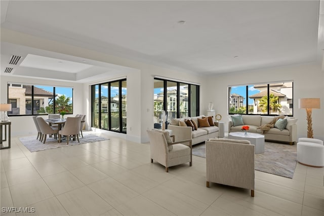 tiled living room featuring a tray ceiling and plenty of natural light