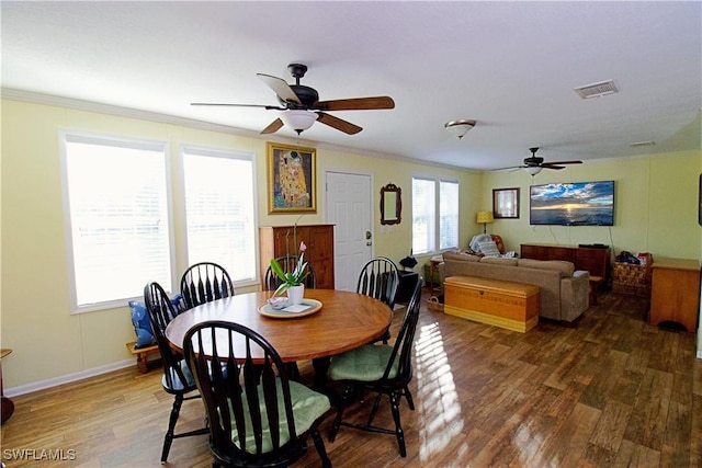 dining space featuring ceiling fan, crown molding, and dark wood-type flooring