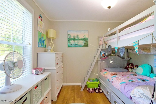 bedroom featuring crown molding and light hardwood / wood-style floors