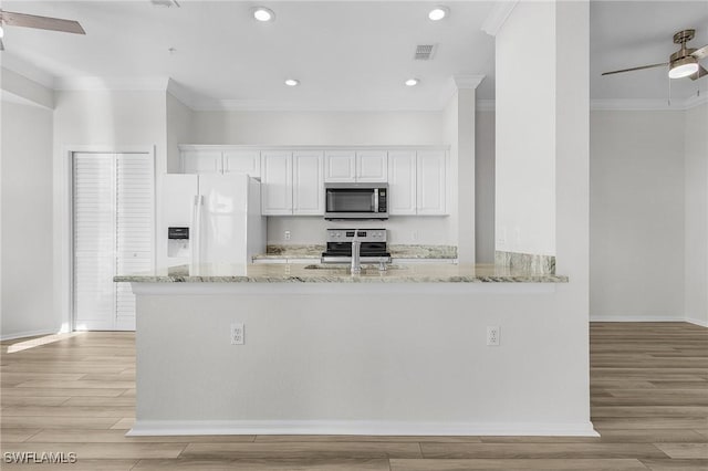 kitchen with white cabinets, stainless steel appliances, light hardwood / wood-style flooring, and light stone countertops