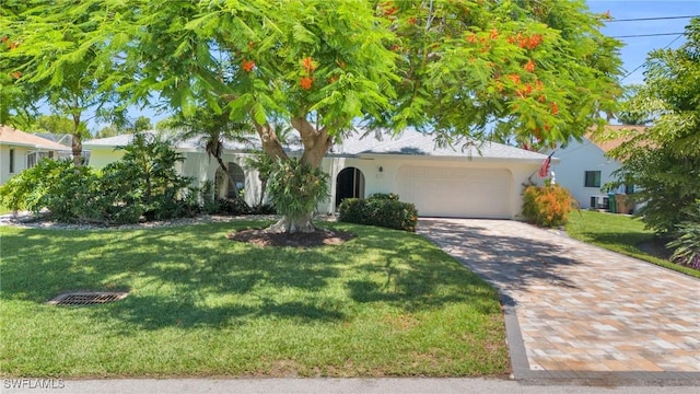 view of front of house featuring central AC unit, a garage, and a front lawn