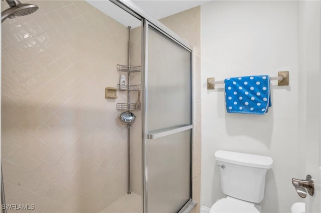 bathroom featuring toilet and an enclosed shower