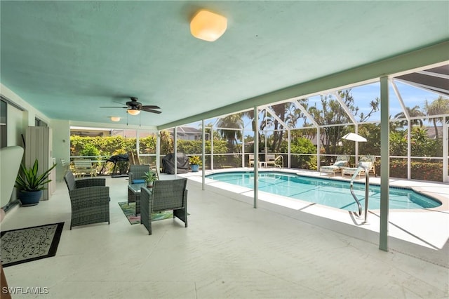 view of pool with glass enclosure, ceiling fan, and a patio