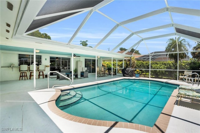 view of pool featuring a lanai, a patio area, ceiling fan, and an outdoor living space