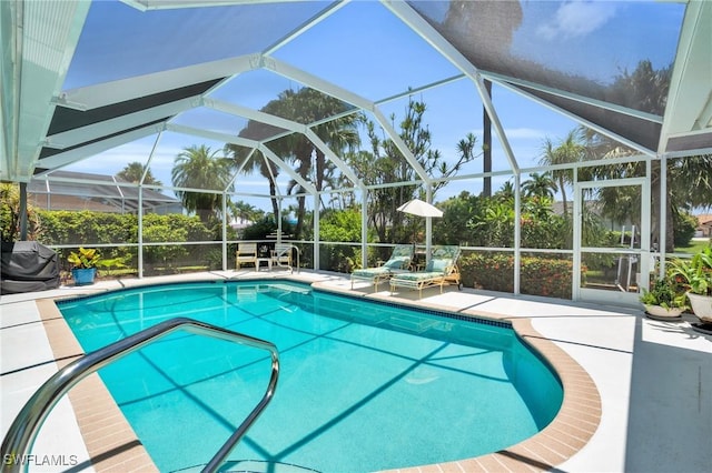 view of swimming pool featuring glass enclosure and a patio area