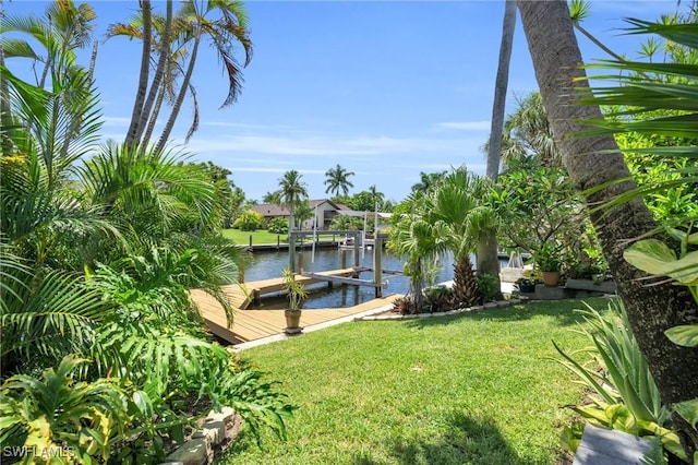 view of dock featuring a lawn and a water view