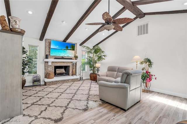 living room featuring ceiling fan, light hardwood / wood-style flooring, and lofted ceiling with beams