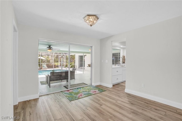 interior space with ceiling fan, light hardwood / wood-style floors, and sink