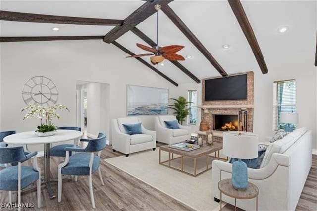 living room featuring beamed ceiling, hardwood / wood-style flooring, high vaulted ceiling, and ceiling fan