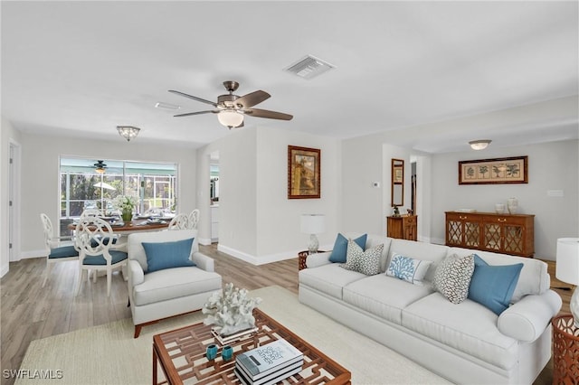 living room featuring light hardwood / wood-style flooring and ceiling fan