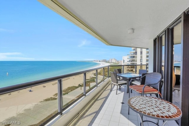 balcony featuring a water view and a beach view