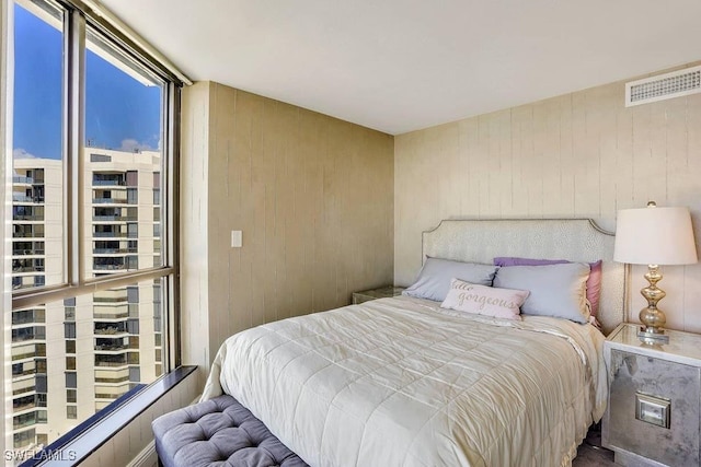 bedroom featuring wooden walls