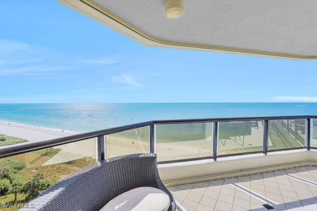 balcony featuring a water view and a beach view