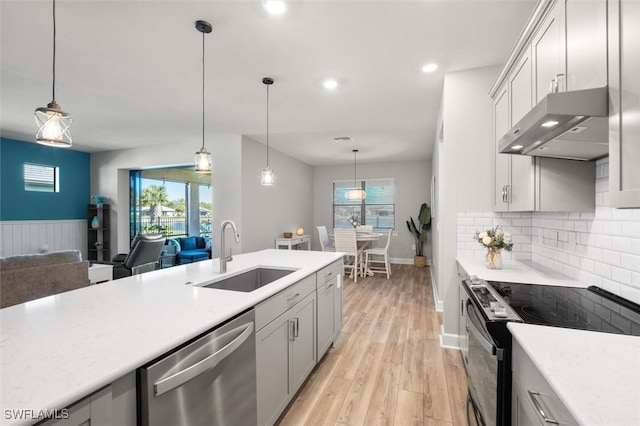 kitchen featuring under cabinet range hood, a sink, electric stove, stainless steel dishwasher, and light countertops