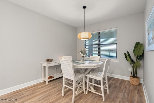 dining area with light wood-type flooring and baseboards