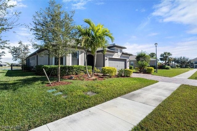 view of front facade featuring a garage, a tile roof, decorative driveway, stucco siding, and a front lawn