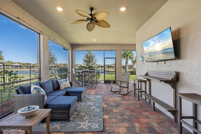 sunroom / solarium featuring a wealth of natural light and ceiling fan