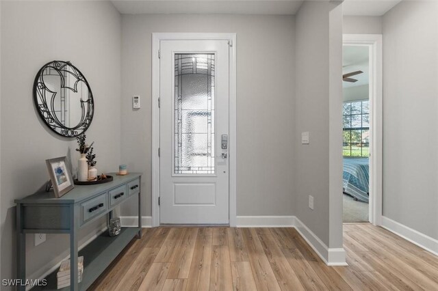 foyer featuring baseboards and light wood-style floors