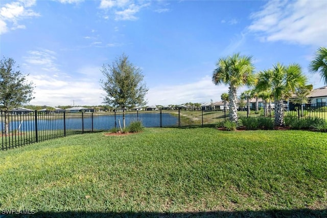 view of yard with a water view and fence