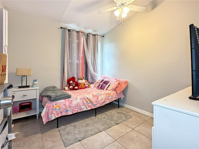 tiled bedroom with ceiling fan and vaulted ceiling