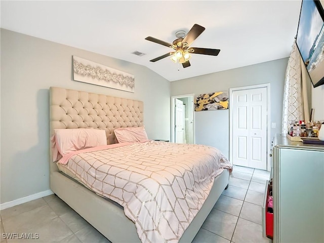 bedroom featuring a closet, vaulted ceiling, ceiling fan, and light tile patterned flooring