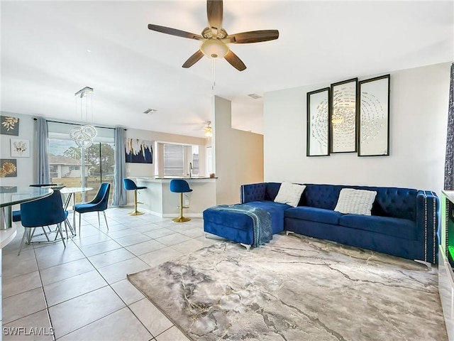 living room with light tile patterned floors and ceiling fan with notable chandelier