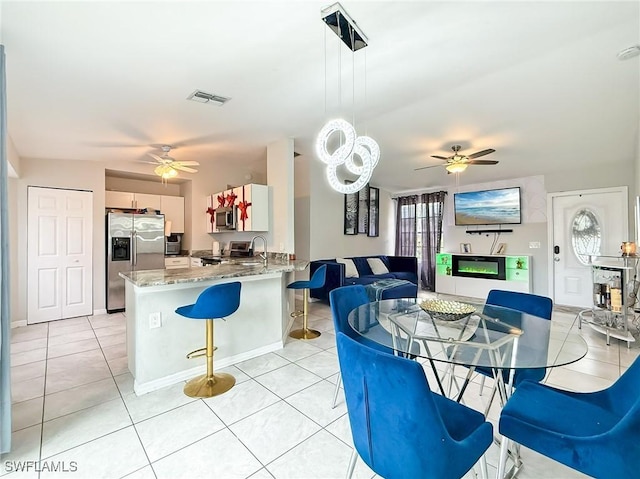 dining room with ceiling fan and light tile patterned flooring