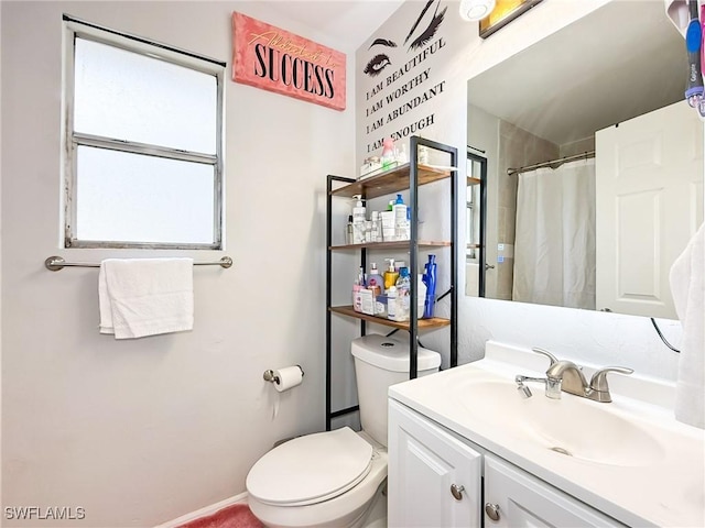 bathroom featuring vanity, curtained shower, and toilet