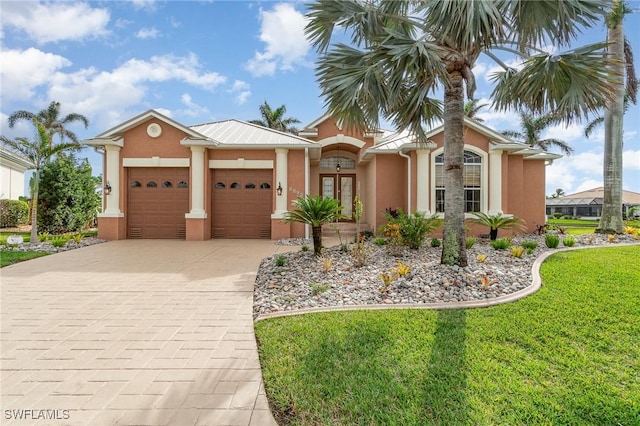 view of front of home with a garage and a front lawn