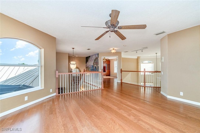 spare room featuring ceiling fan, rail lighting, and light hardwood / wood-style floors