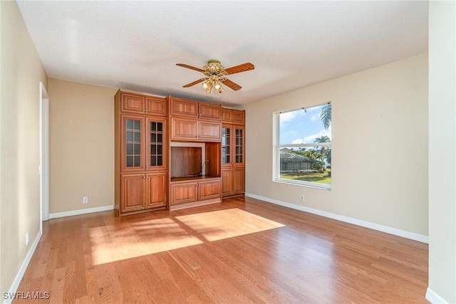 unfurnished living room featuring ceiling fan and light hardwood / wood-style floors