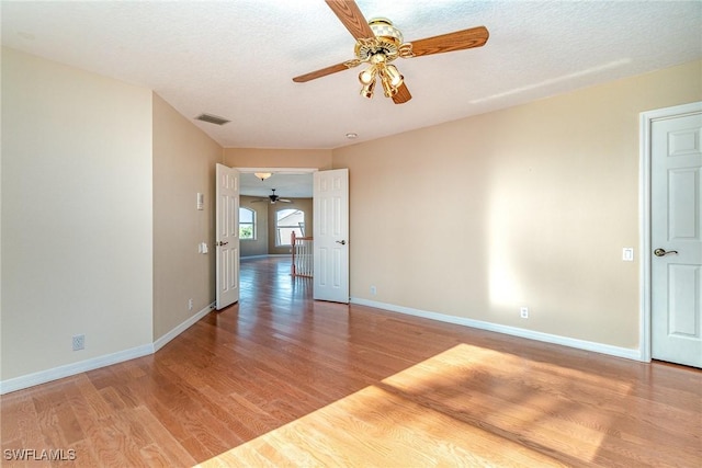 empty room featuring a textured ceiling and light wood-type flooring