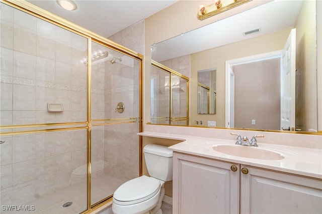 bathroom featuring vanity, toilet, and a shower with shower door