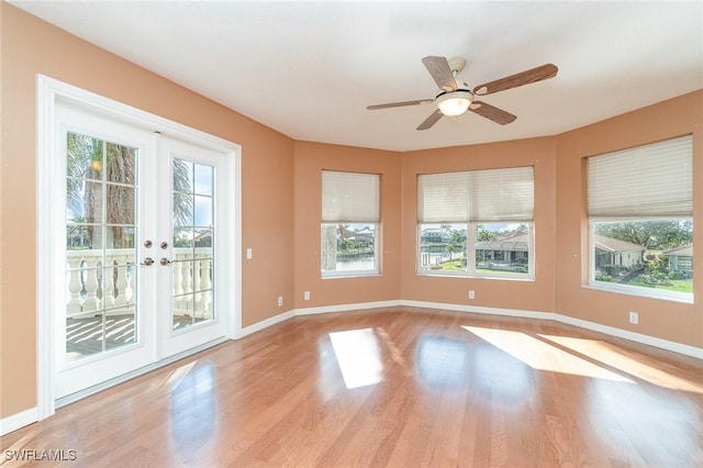 empty room with ceiling fan, french doors, and light hardwood / wood-style flooring