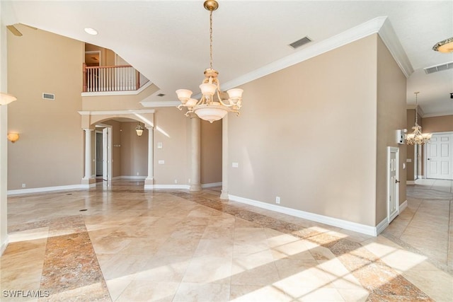 empty room featuring ornate columns, ornamental molding, and a notable chandelier