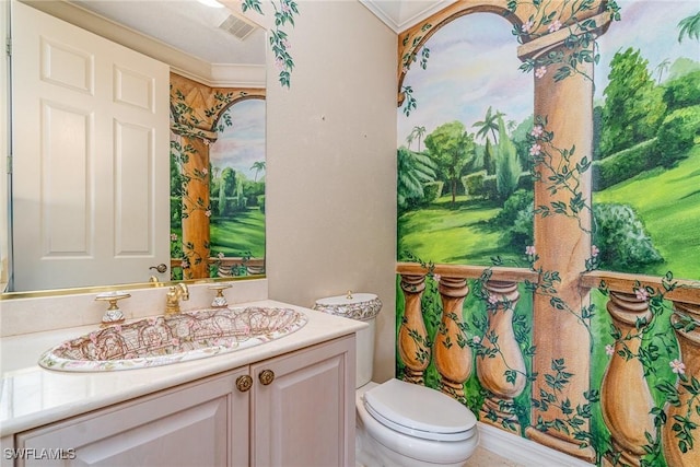 bathroom with vanity, toilet, and ornamental molding