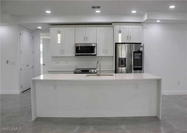 kitchen featuring stainless steel appliances, sink, pendant lighting, a center island with sink, and white cabinetry