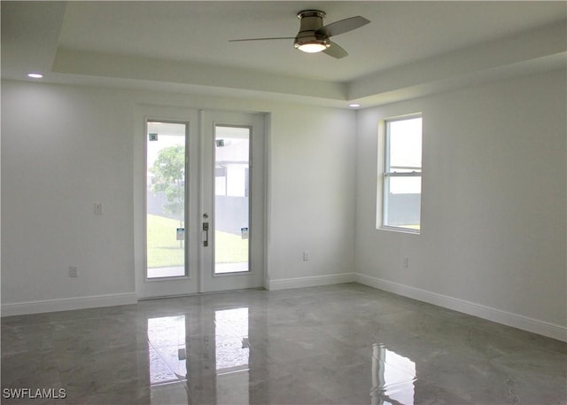 spare room featuring ceiling fan, a raised ceiling, and french doors