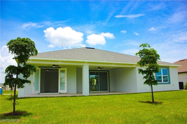 back of house with a lawn and ceiling fan