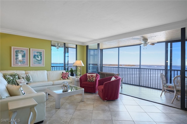 tiled living room with ceiling fan, crown molding, a water view, and a wall of windows