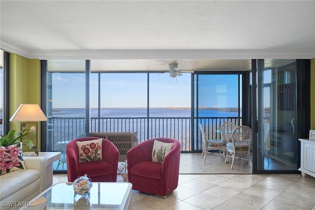 living room featuring light tile patterned floors, a water view, a wall of windows, and ceiling fan