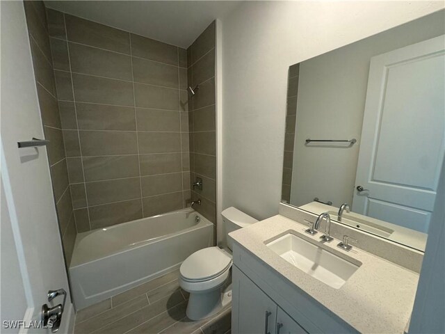 bathroom with toilet, bathtub / shower combination, wood finish floors, and vanity