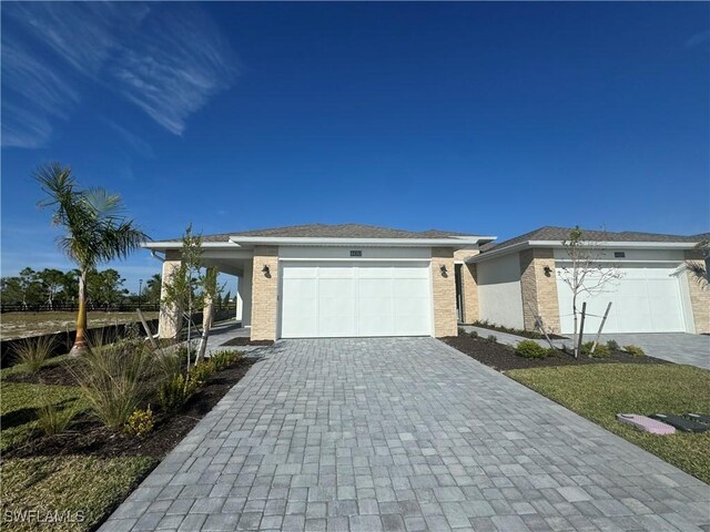 view of front of house featuring a garage, decorative driveway, and stucco siding