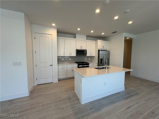 kitchen with black range with electric cooktop, a sink, visible vents, fridge with ice dispenser, and stainless steel microwave