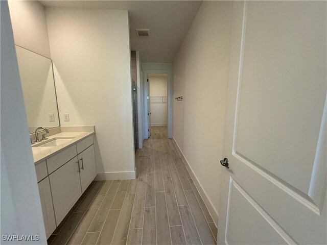 full bath featuring wood tiled floor, visible vents, vanity, and baseboards