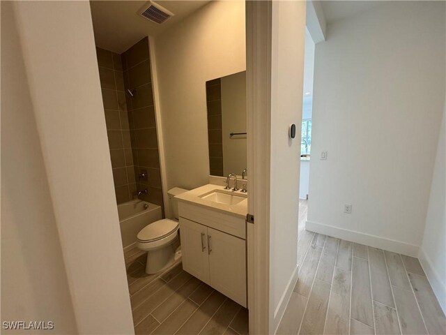 bathroom with toilet, vanity, visible vents, and wood tiled floor