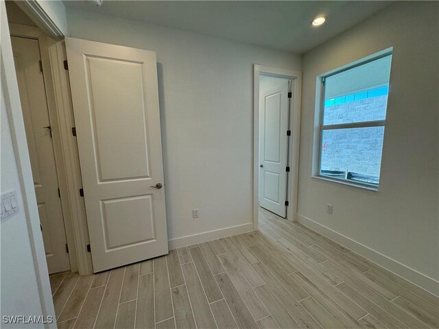 unfurnished bedroom with wood finish floors, baseboards, and recessed lighting